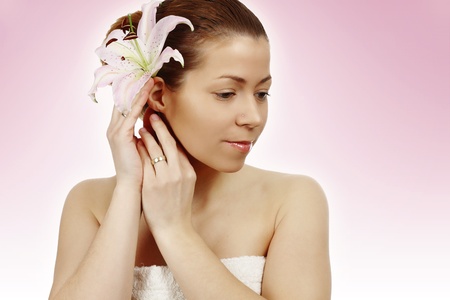 Beautiful young woman with lily flower with towelの写真素材
