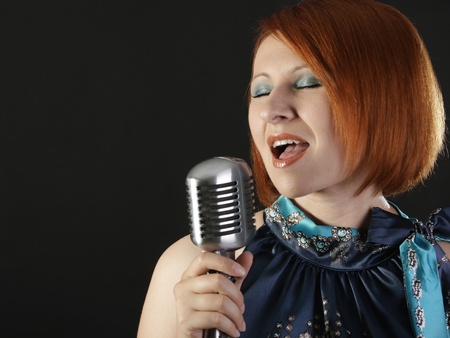 Retro redhead female singer with microphoneの写真素材