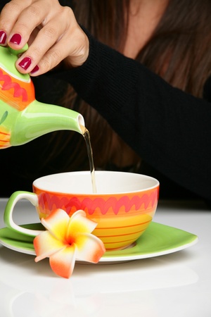 Woman pouring herself a cup of hot teaの写真素材