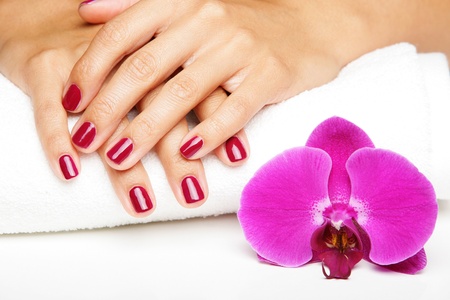 Beautiful hands with manicure and purple orchid flowersの写真素材