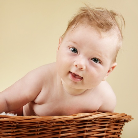 Adorable baby boy in wicker basketの写真素材