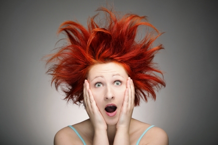 Redhead woman with messy hair against gray backgroundの写真素材