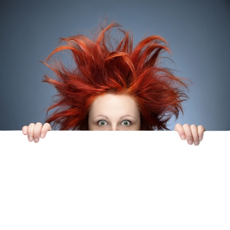 Redhead woman with messy hair against gray backgroundの写真素材