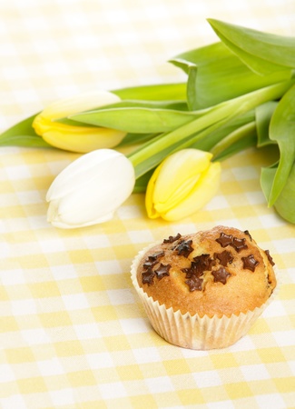 Home baked muffin with tulips in backgroundの写真素材