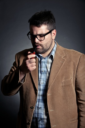 Man with pipe and glasses smokingの写真素材