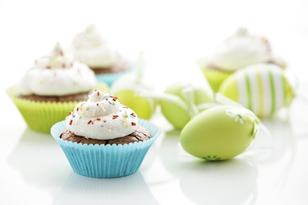 Easter eggs and tasty cupcakes with creamの写真素材