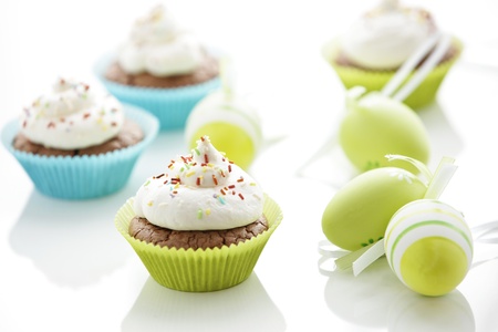 Easter eggs and tasty cupcakes with creamの写真素材