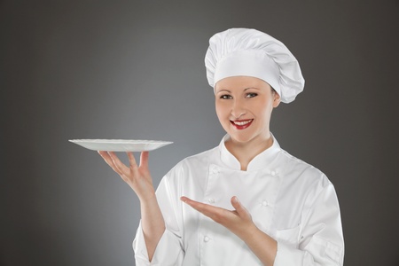 Female chef holding empty plateの写真素材
