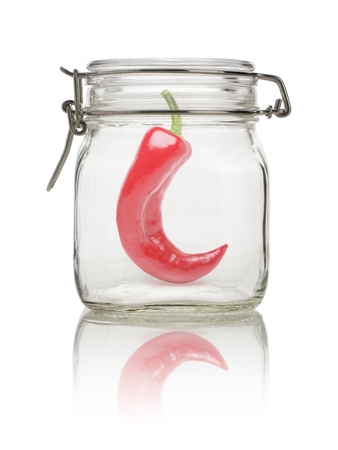 Chilli pepper in glass jar, isolated on whiteの写真素材