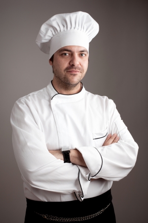Handsome chef posing against gray background の写真素材