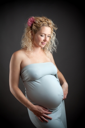 Beautiful pregnant woman against dark bakgroundの写真素材