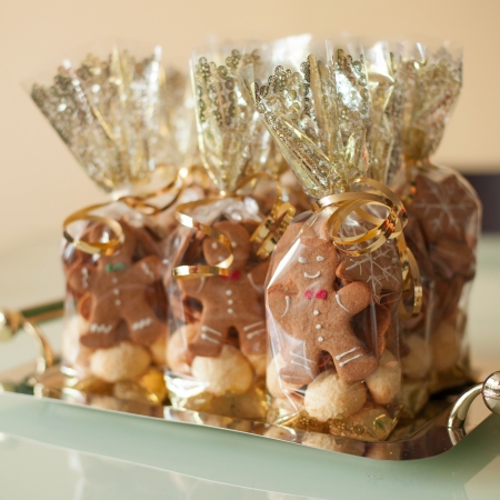 Cute gingerbread cookies in transparent bags with golden ribbonの写真素材