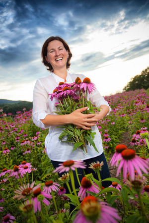 Real farmer woman in coneflower fieldの写真素材