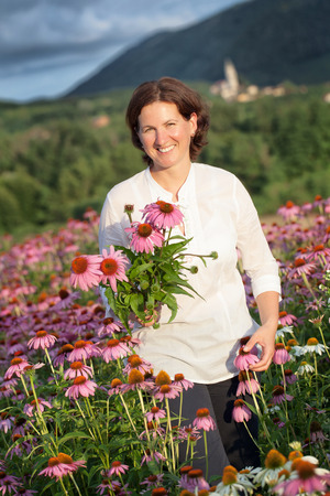 Real farmer woman in coneflower fieldの写真素材
