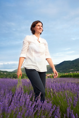 Woman walking with lavender flowers bouquetの写真素材