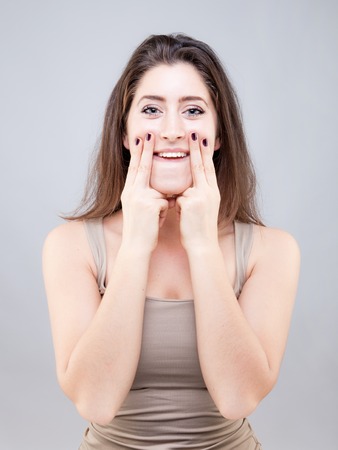 Beautiful young caucasian woman doing face yoga poseの写真素材