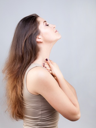 Beautiful young caucasian woman doing face yoga poseの写真素材