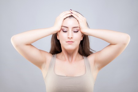 Beautiful young caucasian woman doing face yoga poseの写真素材