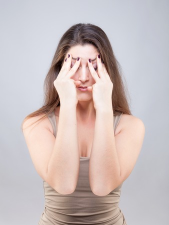 Beautiful young caucasian woman doing face yoga poseの写真素材