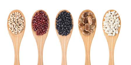 Different sorts of beans on wooden spoon isolated on whiteの写真素材