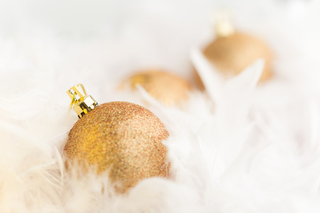 Golden Christmas Baubles in white featherの写真素材