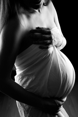 Beautiful pregnant woman in white shirtの写真素材