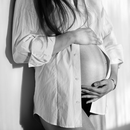 Beautiful pregnant woman in white shirt