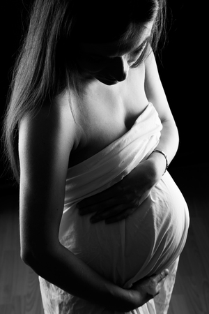 Beautiful pregnant woman in white shirtの写真素材