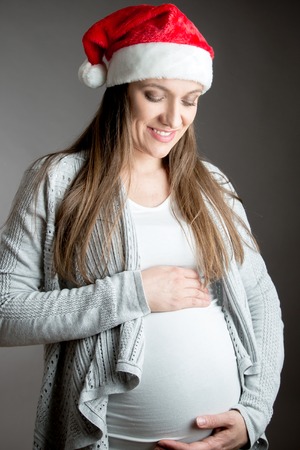 Young beautiful pregnant woman in winter studio shotの写真素材