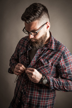 Young caucasian handsome hipster with beard posing in studioの写真素材
