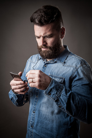 Young caucasian handsome hipster with beard posing in studioの写真素材