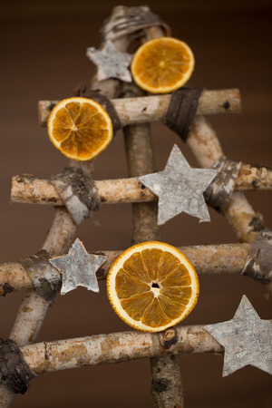 Different christmas tree made of sticks and decorated with orange slicesの写真素材