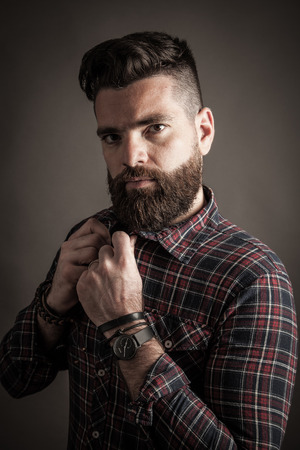 Young caucasian handsome hipster with beard posing in studioの写真素材
