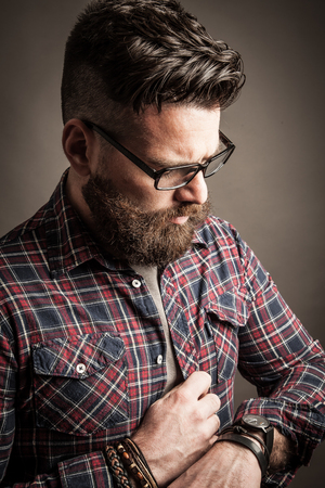 Young caucasian handsome hipster with beard posing in studioの写真素材