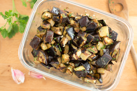 Diced eggplant with garlic and parsley in glass dishの写真素材