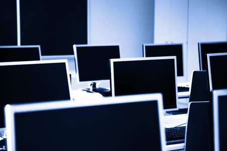 Empty computer classroom with many computer workstations