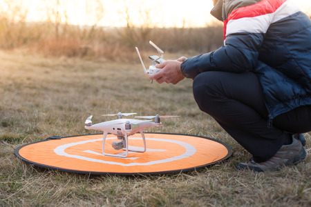 Man with drone and remote control in winter natureの写真素材