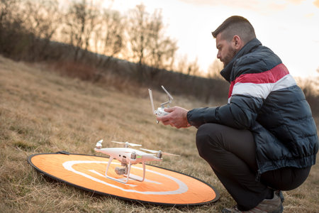 Man with drone and remote control in winter nature