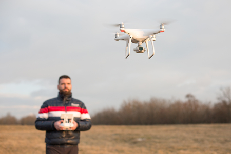 Man with drone and remote control in winter natureの写真素材