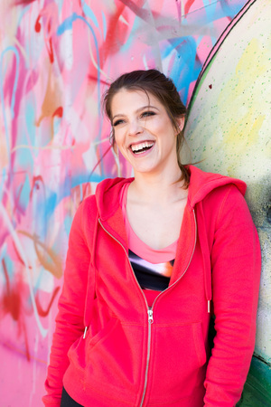 Fit young woman leaning on graffiti wallの写真素材