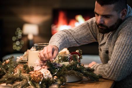 Bearded man decorating christmas table with bubblesの写真素材