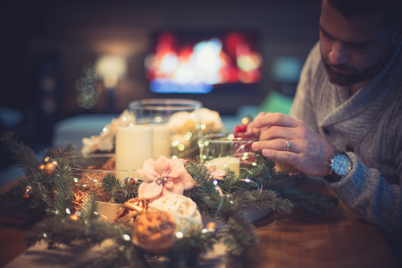 Bearded man decorating christmas table with bubblesの写真素材