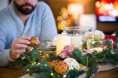 Bearded man decorating christmas table with bubblesの写真素材