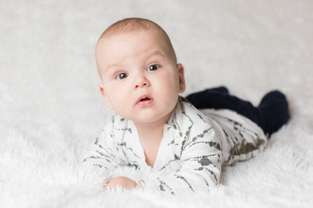 Few months old baby boy on soft white blanket