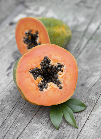 Cut papaya fruit on wooden backgroundの写真素材