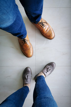 Overhead view of couple wearing leather shoes