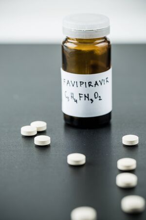 Favipiravir experimental drug for treating covid 19 on dramatic dark background with copy spaceの写真素材