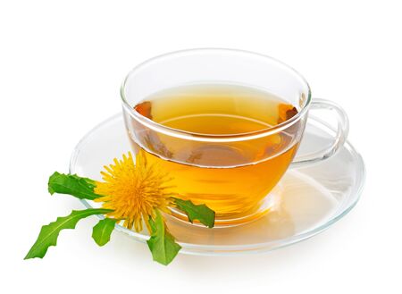 Dandelion tea in a transparent cup with dandelion flower and leaves on white backgroundの写真素材
