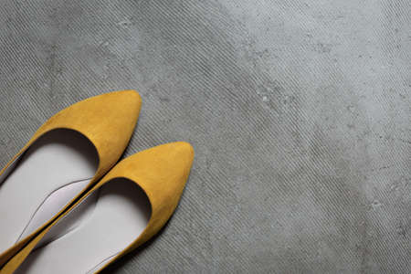 Flat yellow female shoes on gray floor, colors of 2021の写真素材