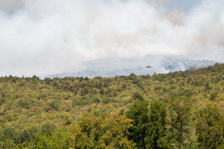 Helicopter against wildfire during strong wind and droughtの写真素材